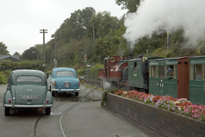 Vintage cars complement the train to make a timeless scene at Penrhyn