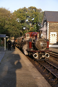 Resplendent in 'new' livery, Merddin Emrys basks in the dusk sunshine next to Minffordd platform shelter.